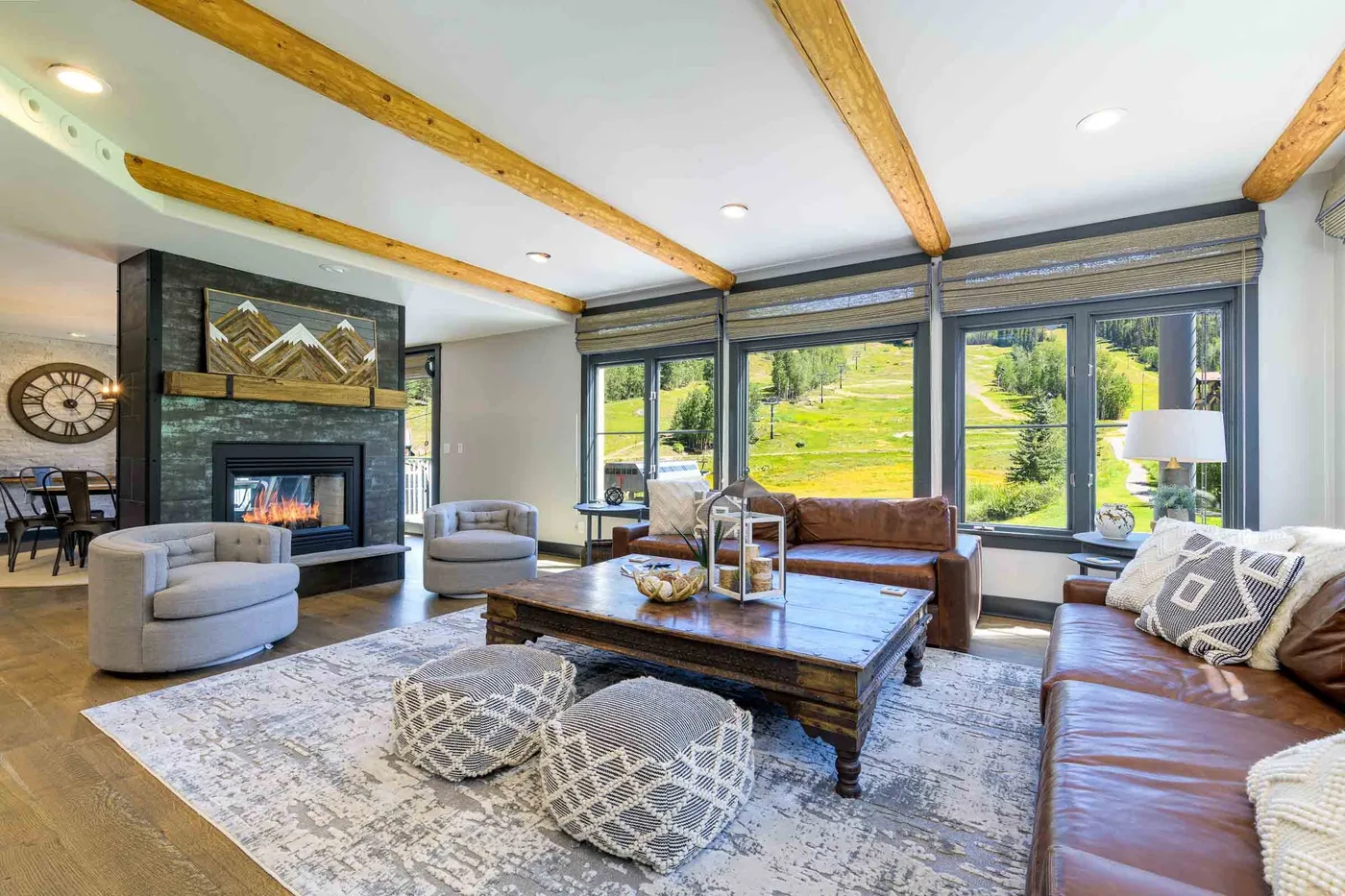 A spacious living room with seating around a coffee table and a fireplace.
