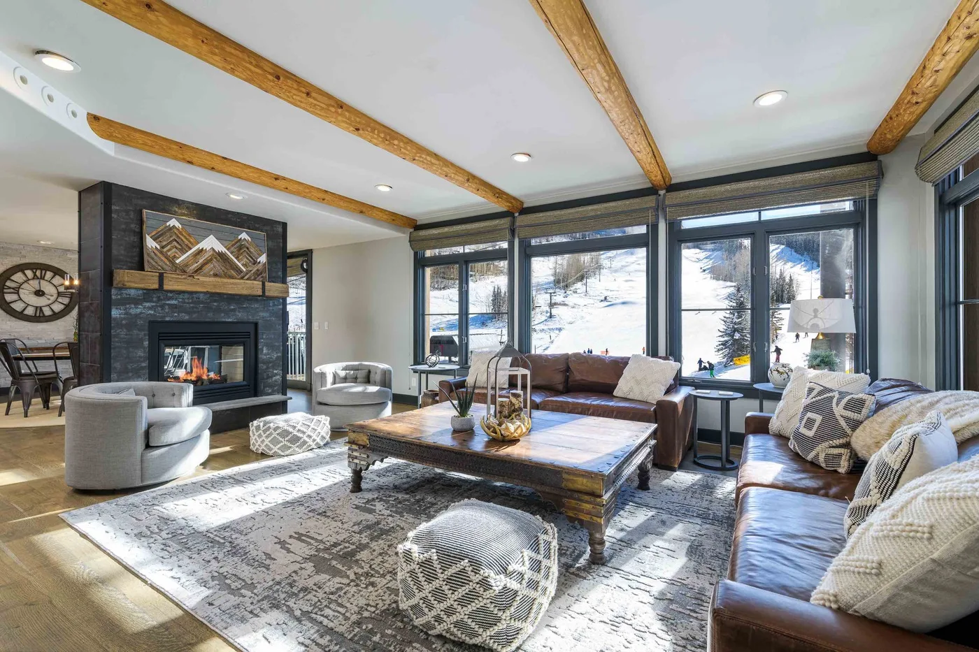 A living room with seating around a coffee table and a fireplace.