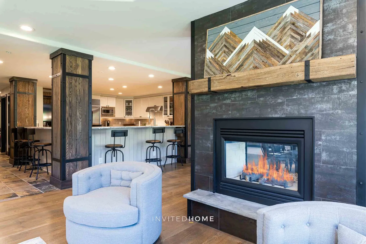 An open-plan living area with a fireplace and kitchen seating.