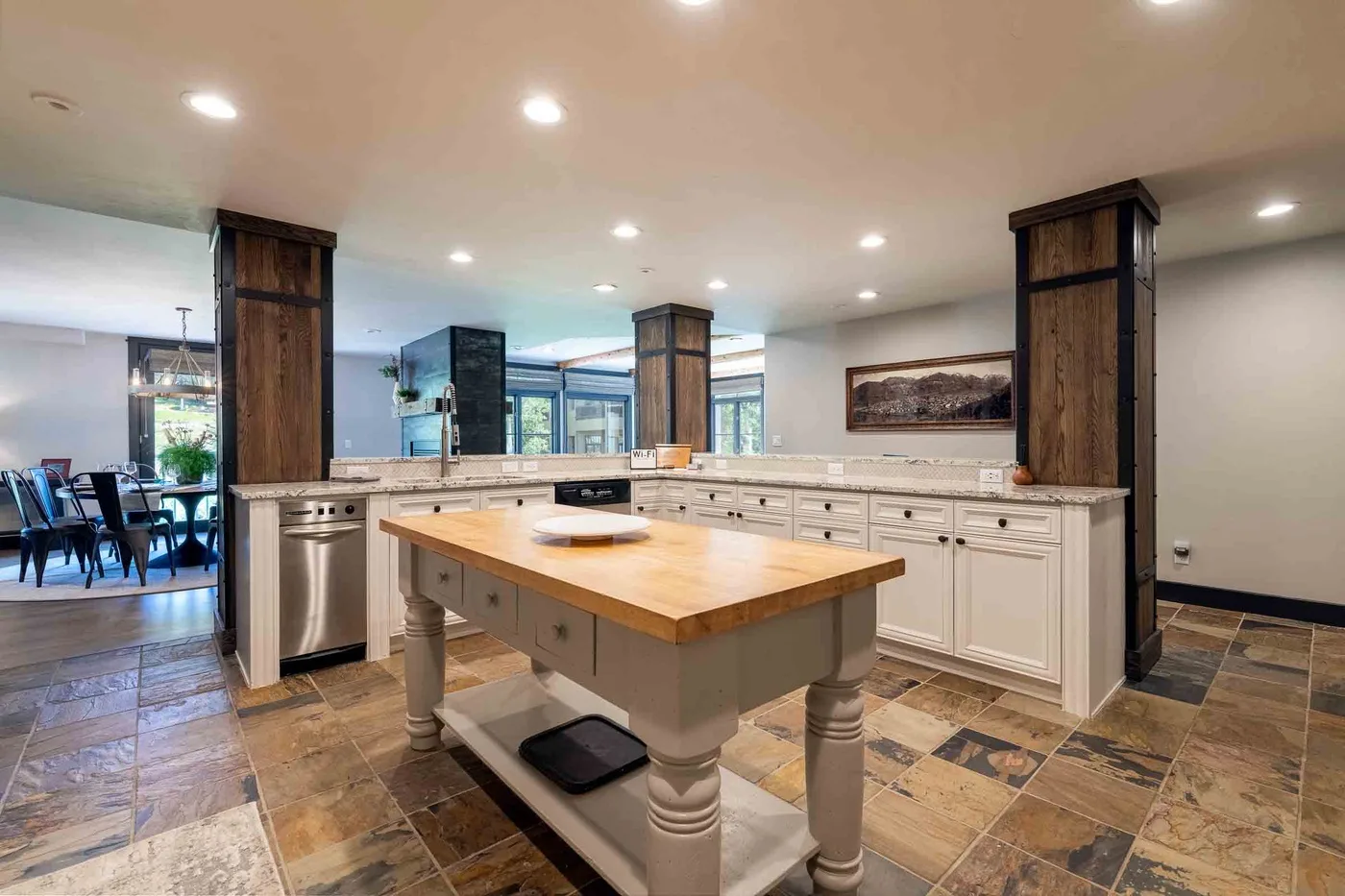A spacious kitchen with a central island and dining area visible beyond.