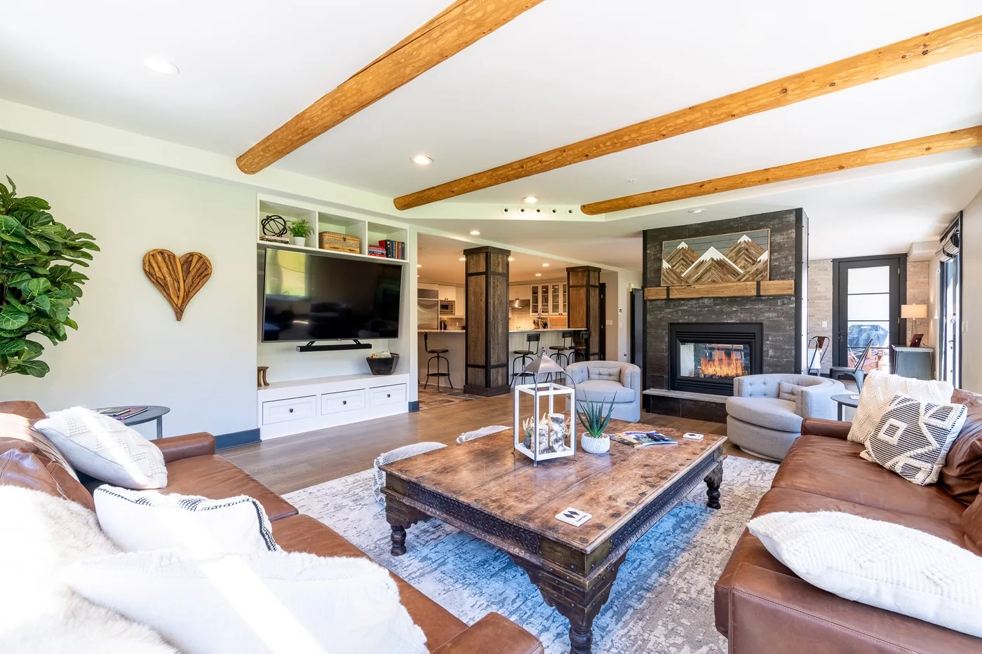 Living room with seating arranged around a coffee table and fireplace.