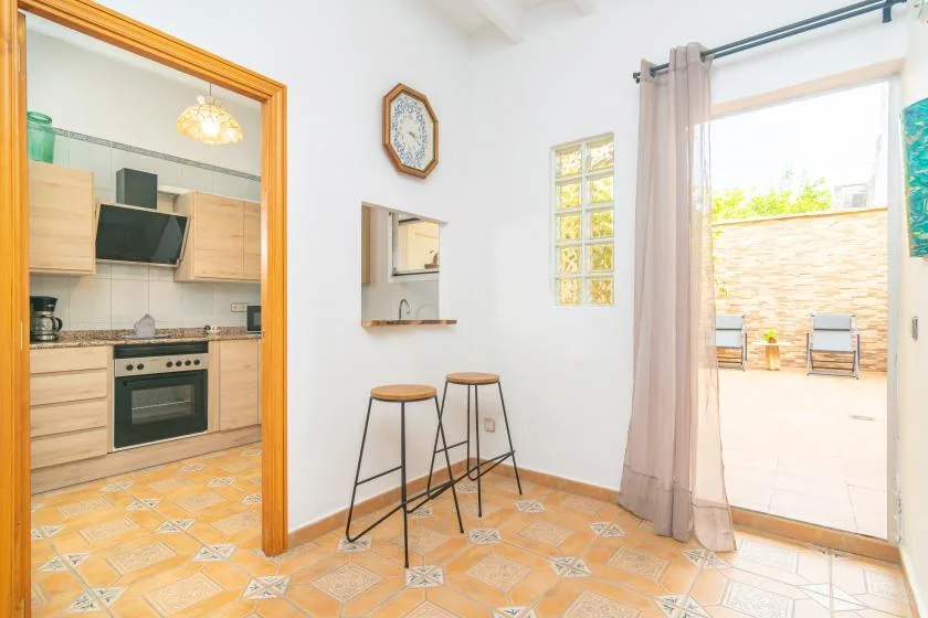 A bright dining area with a small counter and an open doorway to a patio.