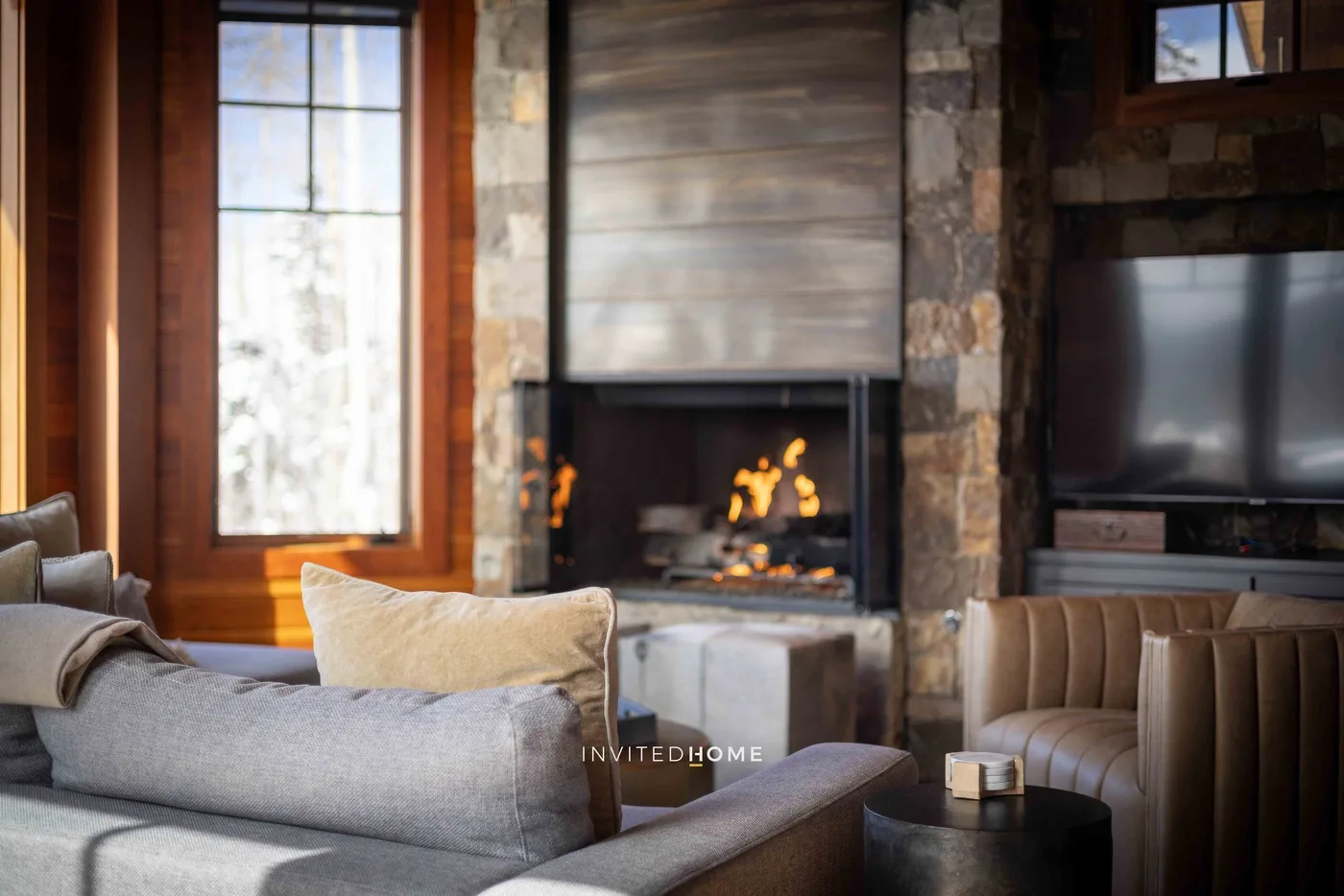 A living room with seating around a fireplace and television.