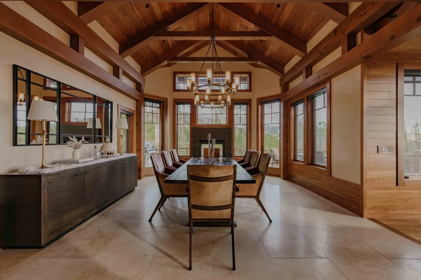 A dining room with a long table beneath an exposed timber ceiling.