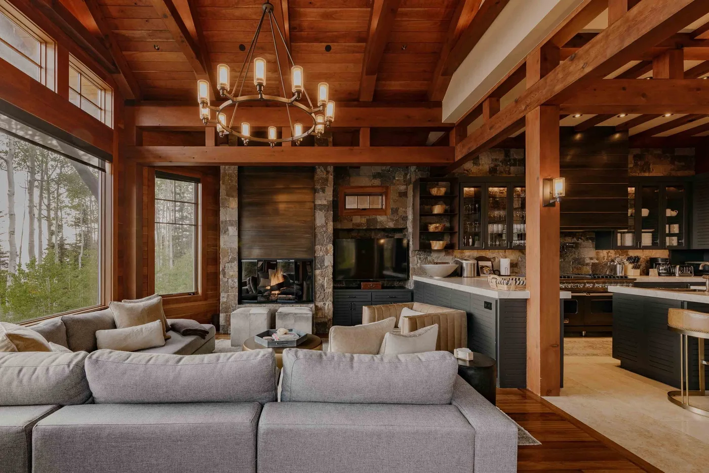 A spacious living room with seating, a fireplace, and an open kitchen.