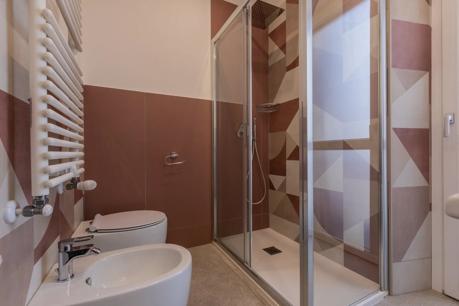 A bathroom with a sink, toilet, and glass-enclosed shower.