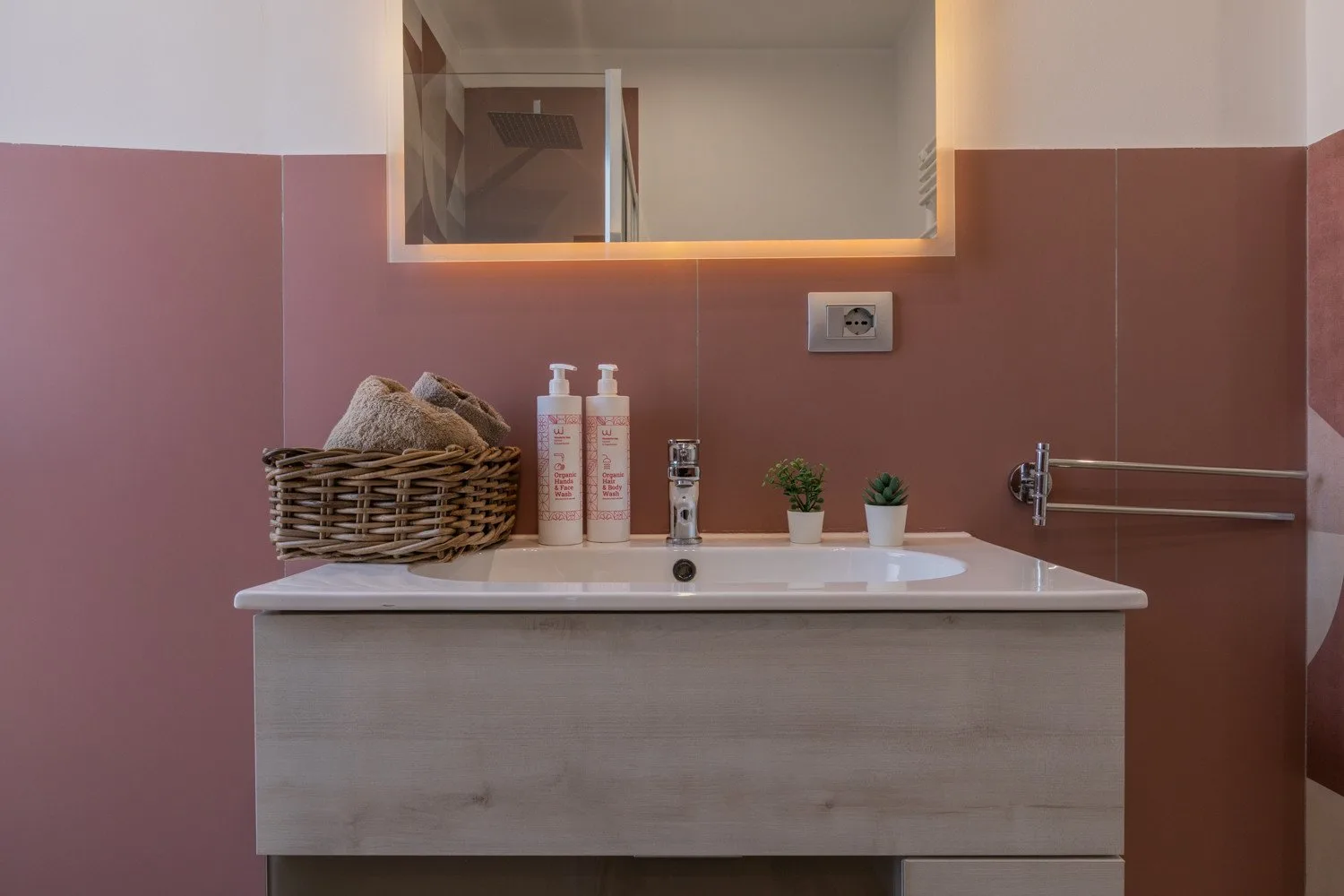 A bathroom vanity with a sink, toiletries, and a mirror.