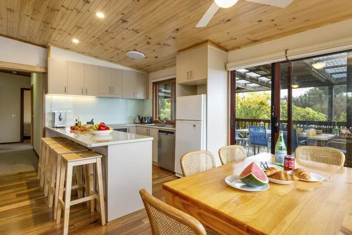Una luminosa cocina y comedor se abre a un patio a través de grandes puertas de vidrio.