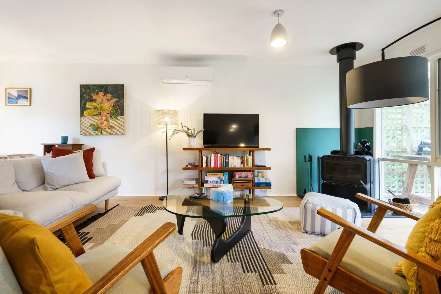 Una zona de estar de planta abierta, equipada con un sofá y dos sillones, ofrece el lugar perfecto para acomodarse y ver una película al final del día.