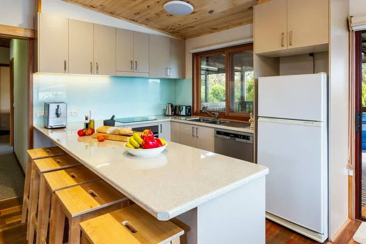 Una cocina luminosa con una isla grande y armarios junto a la pared.