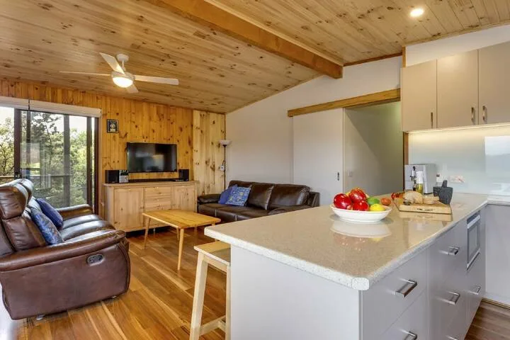 Sala de estar y cocina de planta abierta, con una isla central y una zona de asientos.