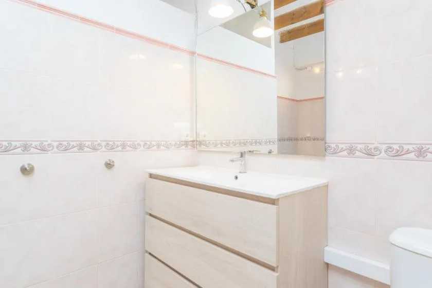 A bright bathroom vanity with a sink and a large mirror.