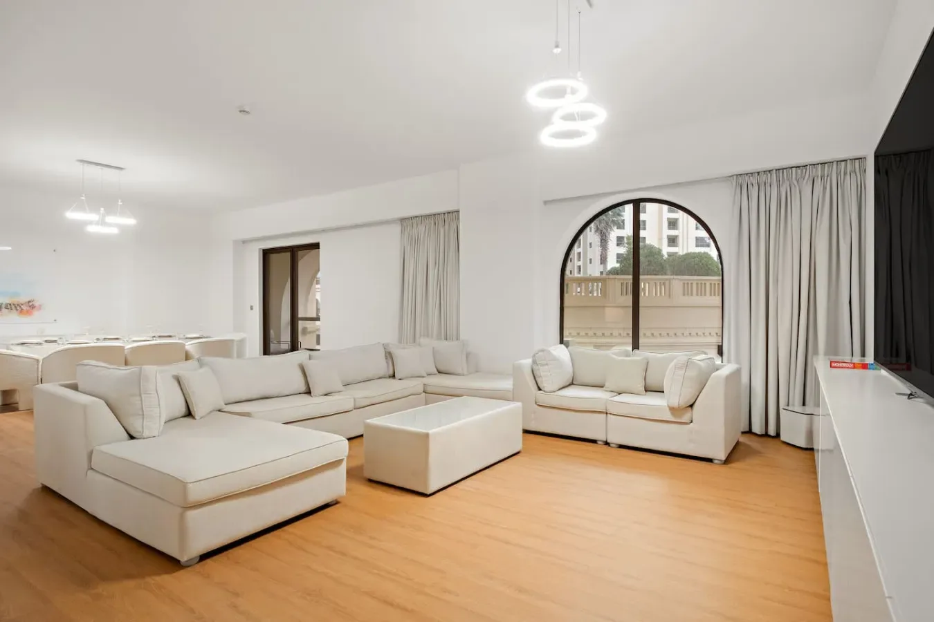 Una sala luminosa con asientos claros, una mesa de centro y ventanales.