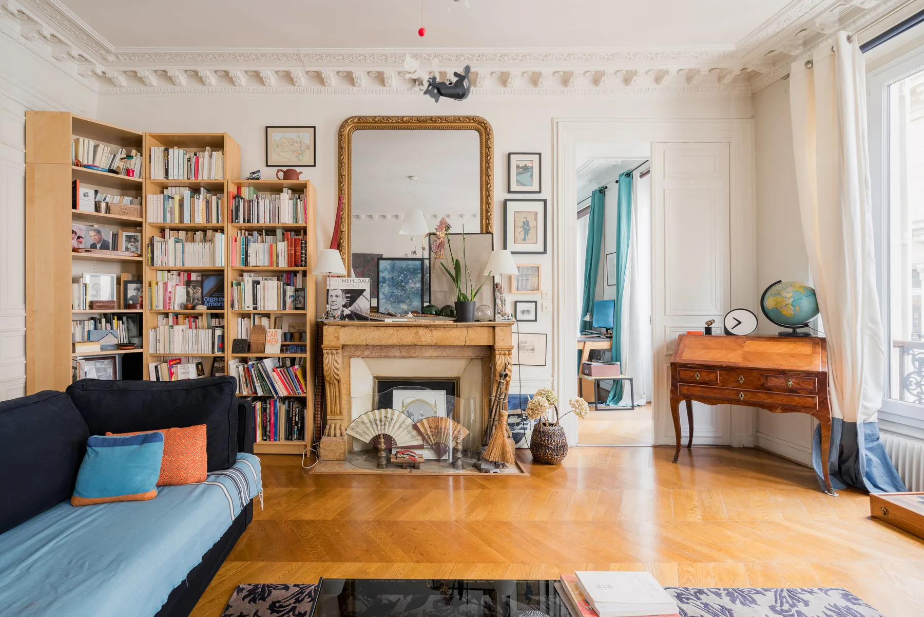 A bright living room with bookshelves, a fireplace, and seating.