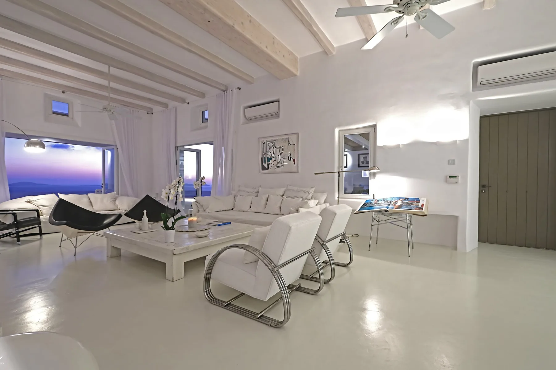 A bright living room with white seating and a low coffee table.