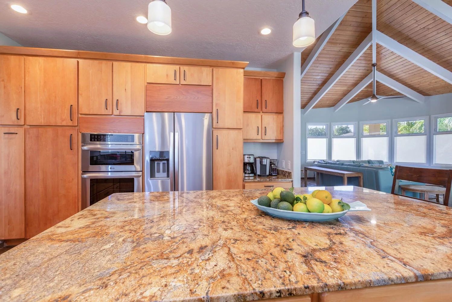 Una cocina con gabinetes de madera y una amplia encimera de piedra.