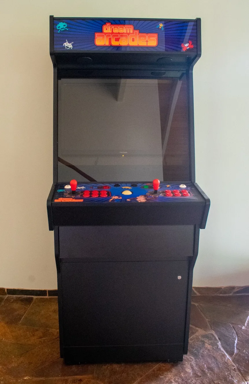 Una máquina recreativa está junto a una pared de color claro.