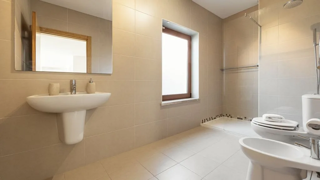 Un baño alicatado con un lavabo de pared y una ducha.