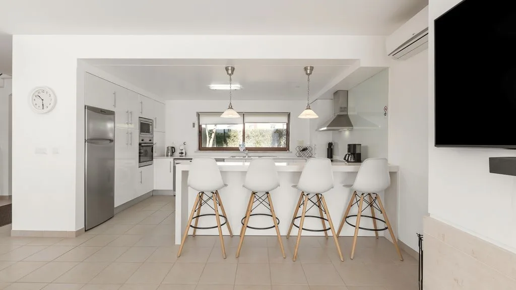 Una cocina luminosa y comedor abierto con una barra y asientos.