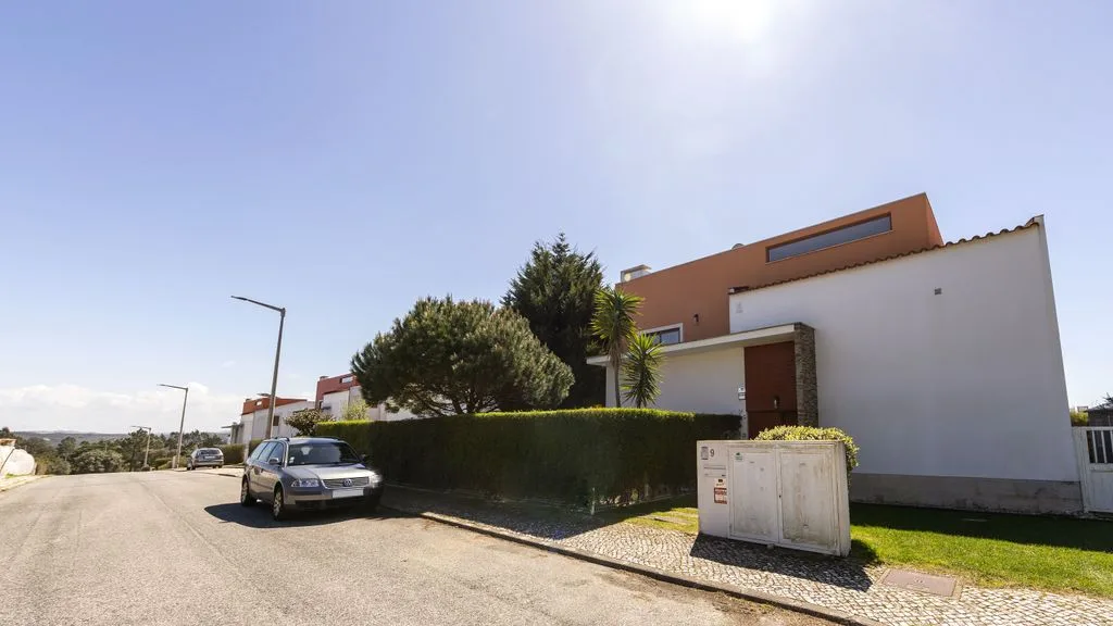 Una casa moderna se encuentra junto a una tranquila calle residencial.