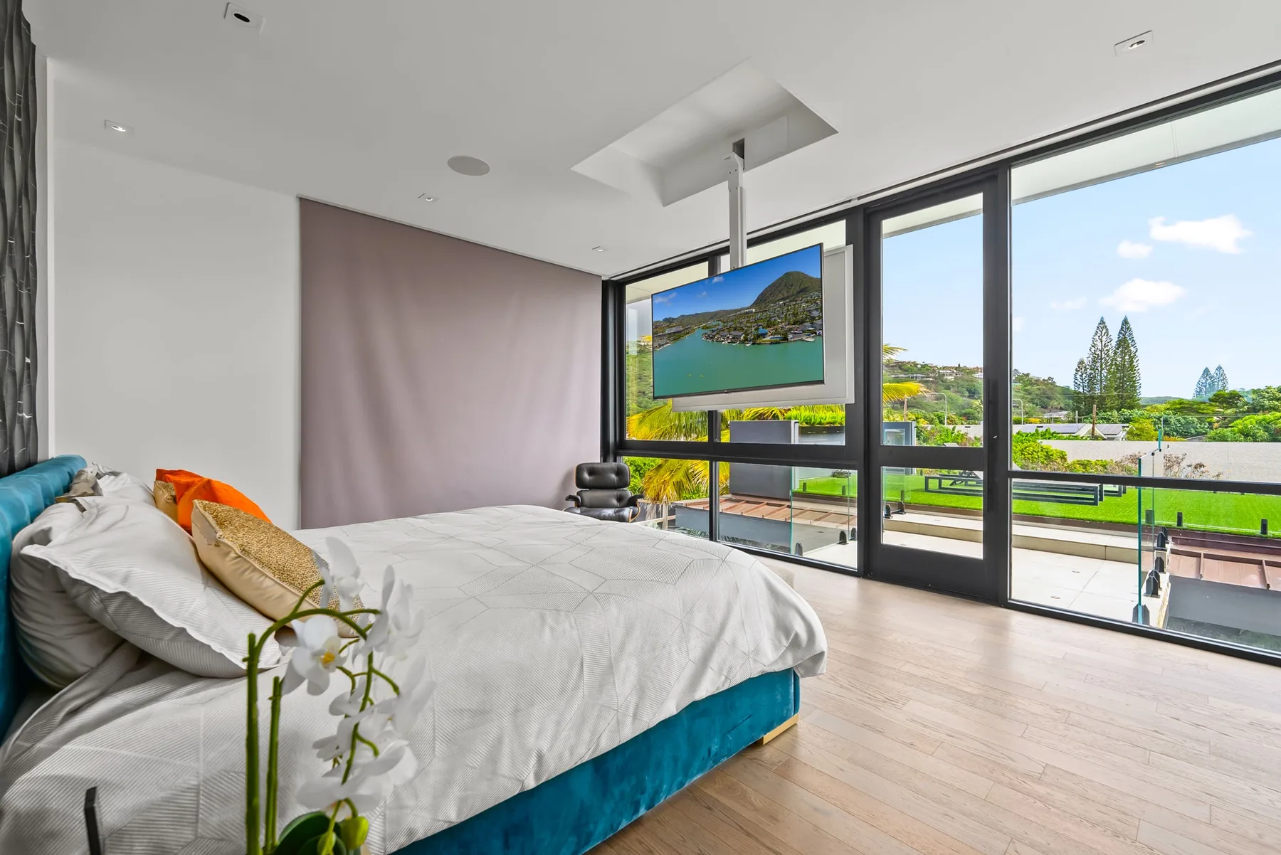 Un dormitorio luminoso con una cama junto a ventanales que dan a un jardín.