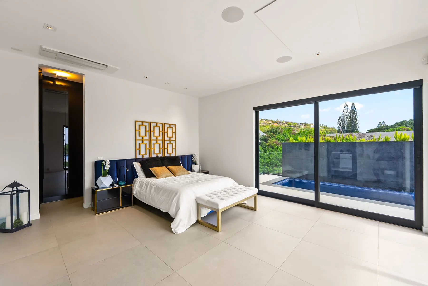 Un dormitorio luminoso con una cama grande y puertas corredizas de vidrio que dan a un patio.