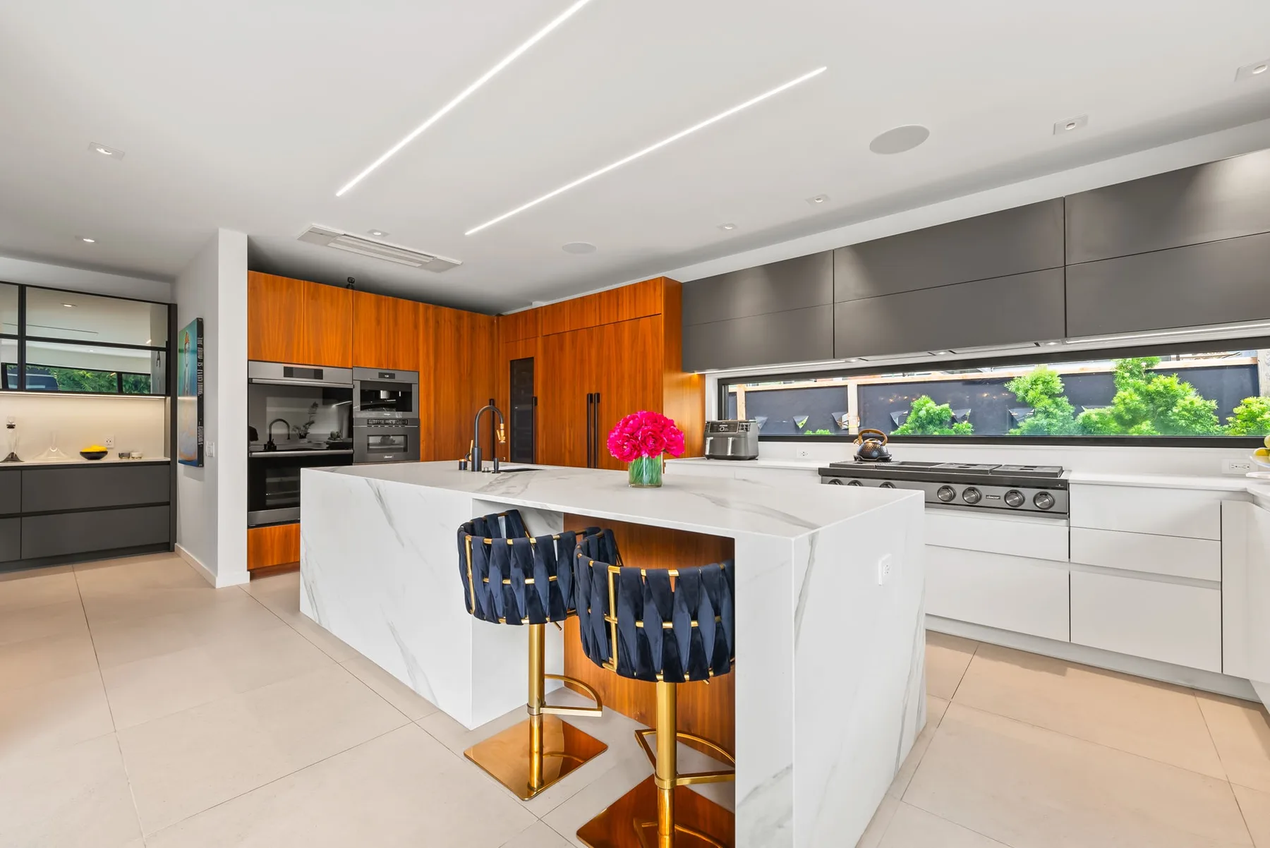Una cocina moderna con una isla grande y gabinetes de madera naranja.