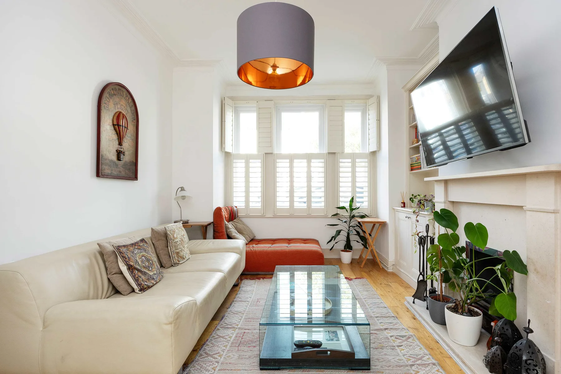 Una sala luminosa con asientos, una mesa de centro de vidrio y una chimenea.