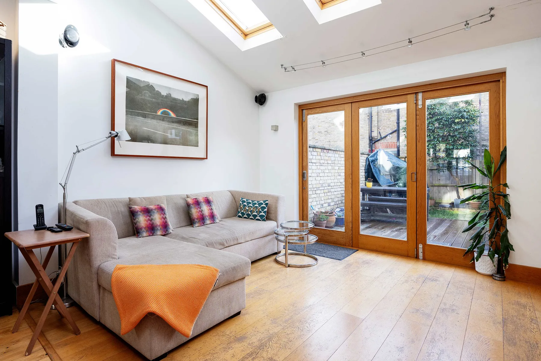 Una sala luminosa con asientos junto a grandes puertas de vidrio que dan a un patio.