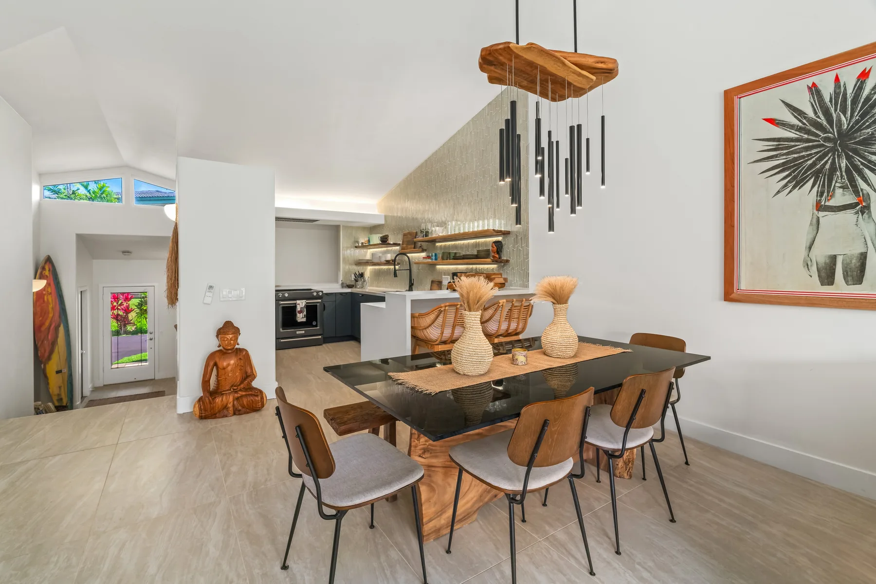 Open-plan dining area and kitchen with a table beneath a hanging light.