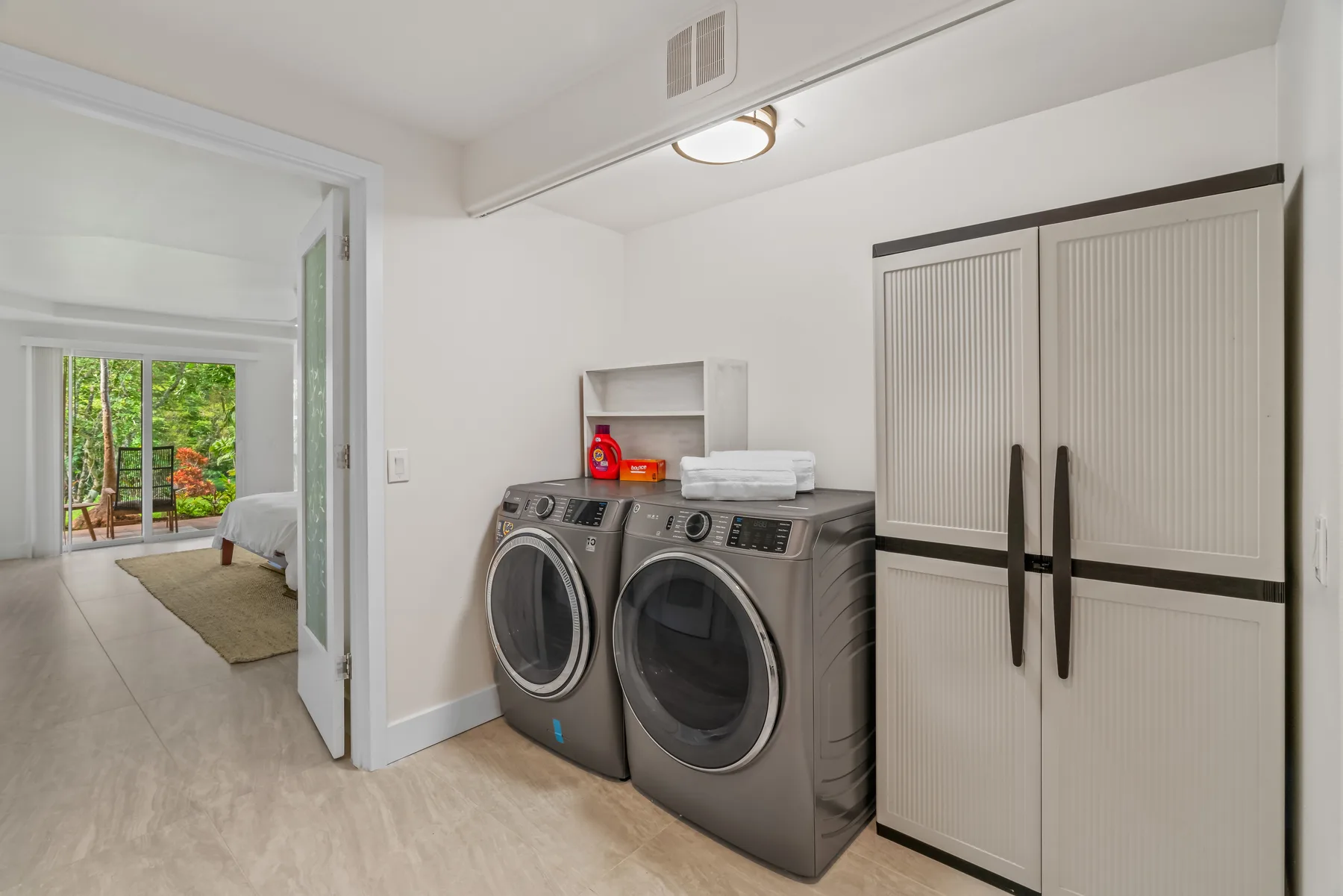 A laundry area with a washer and dryer beside a tall storage cabinet.