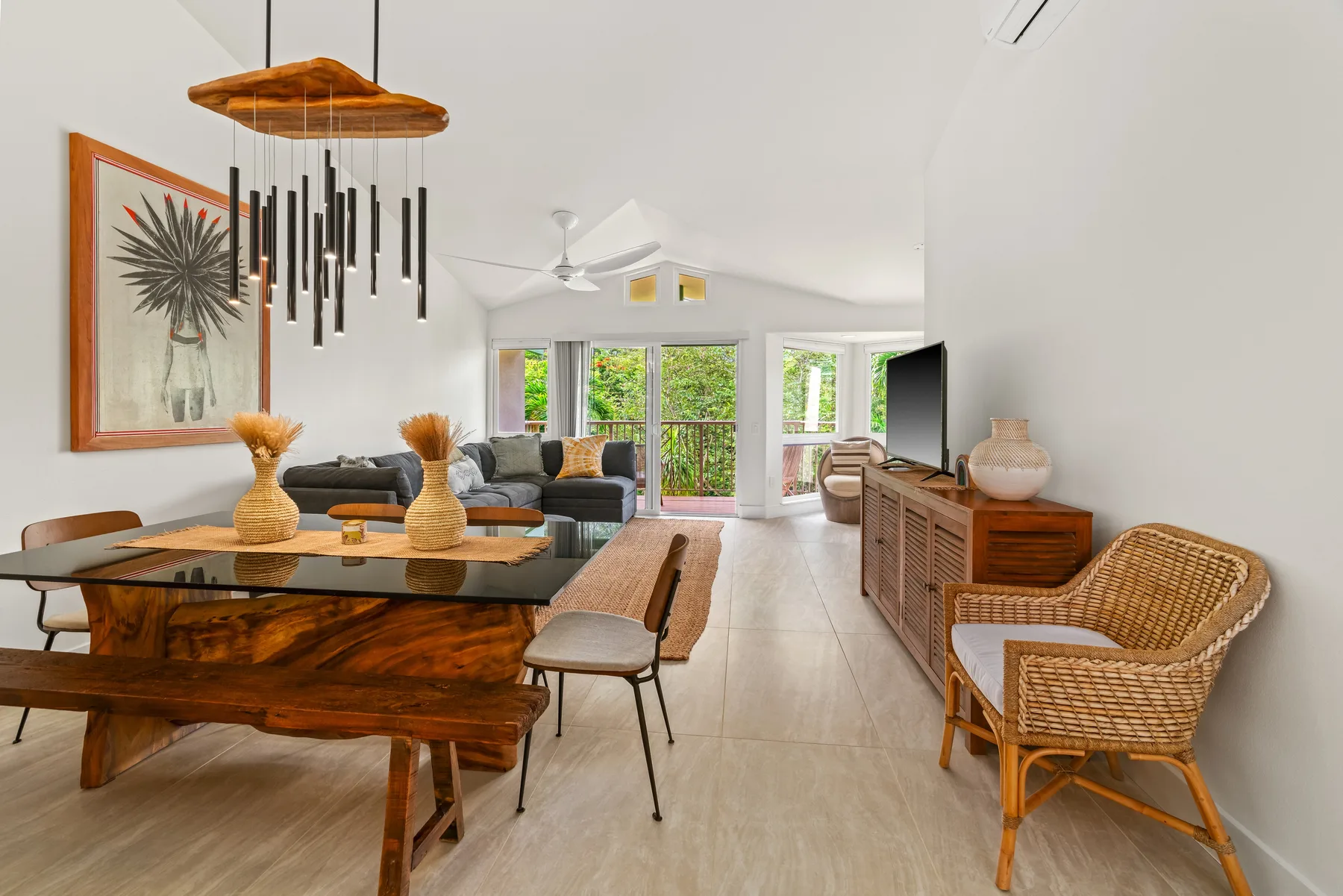 A bright living and dining area with a wooden dining table and seating.