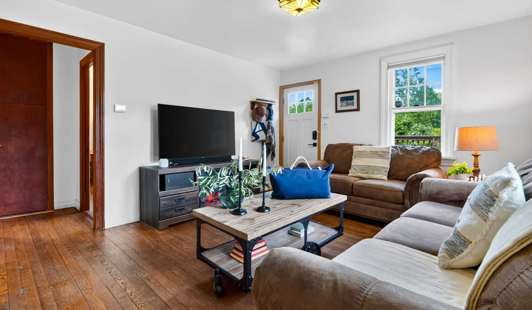 Una sala de estar con asientos, un televisor y una mesa de centro.