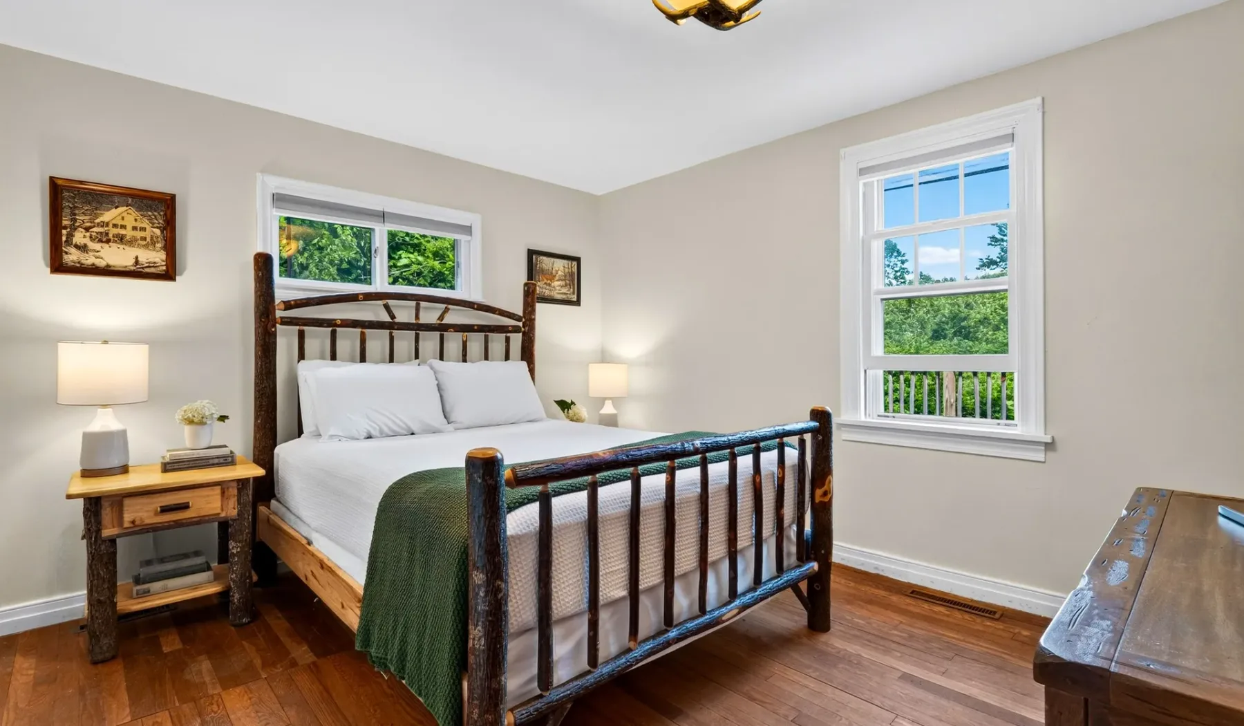 Un dormitorio con una cama de madera, ropa de cama blanca y ventanas.