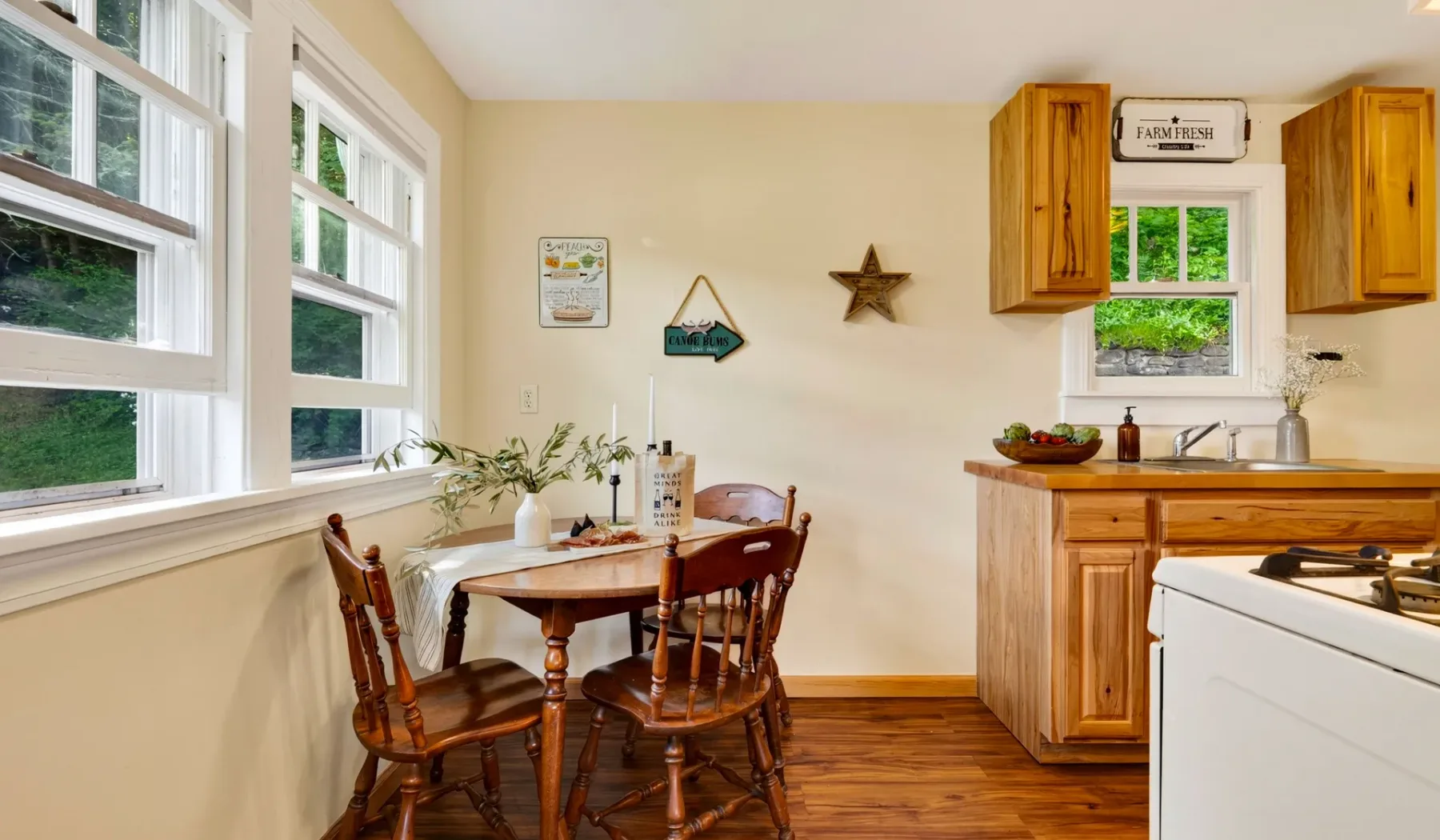 Una cocina luminosa con una mesa de comedor junto a grandes ventanas.
