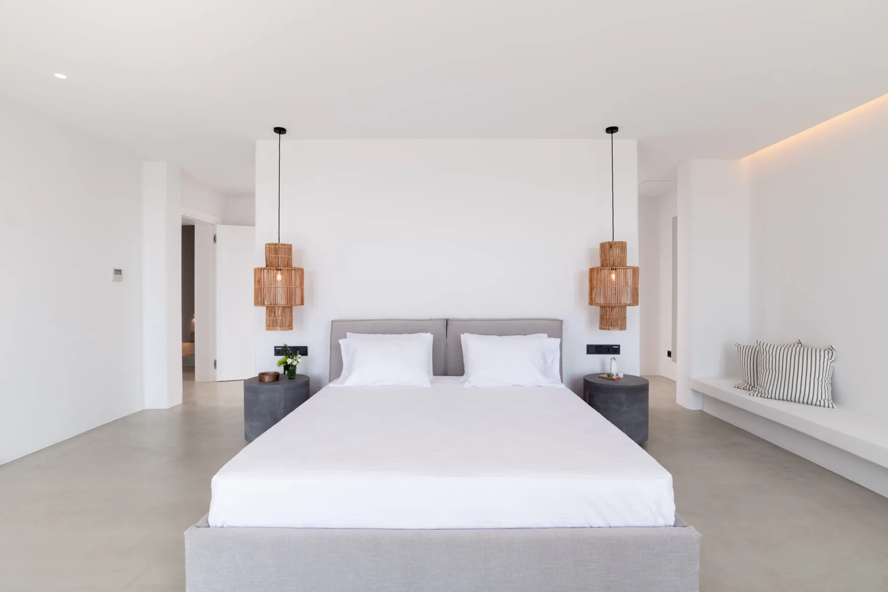 A bright bedroom with a large bed and matching bedside tables.