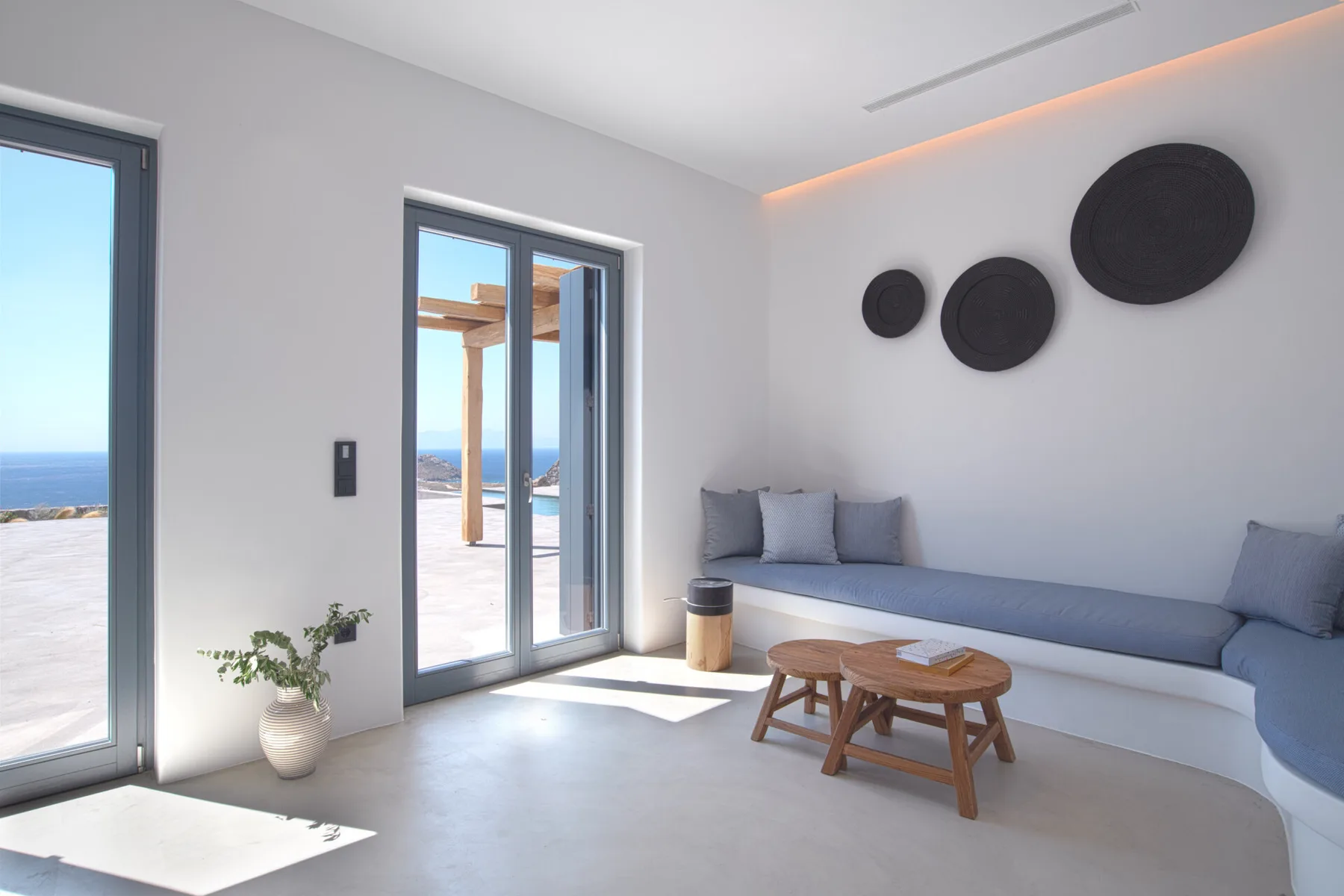 A bright living room with built-in seating and a wooden coffee table.