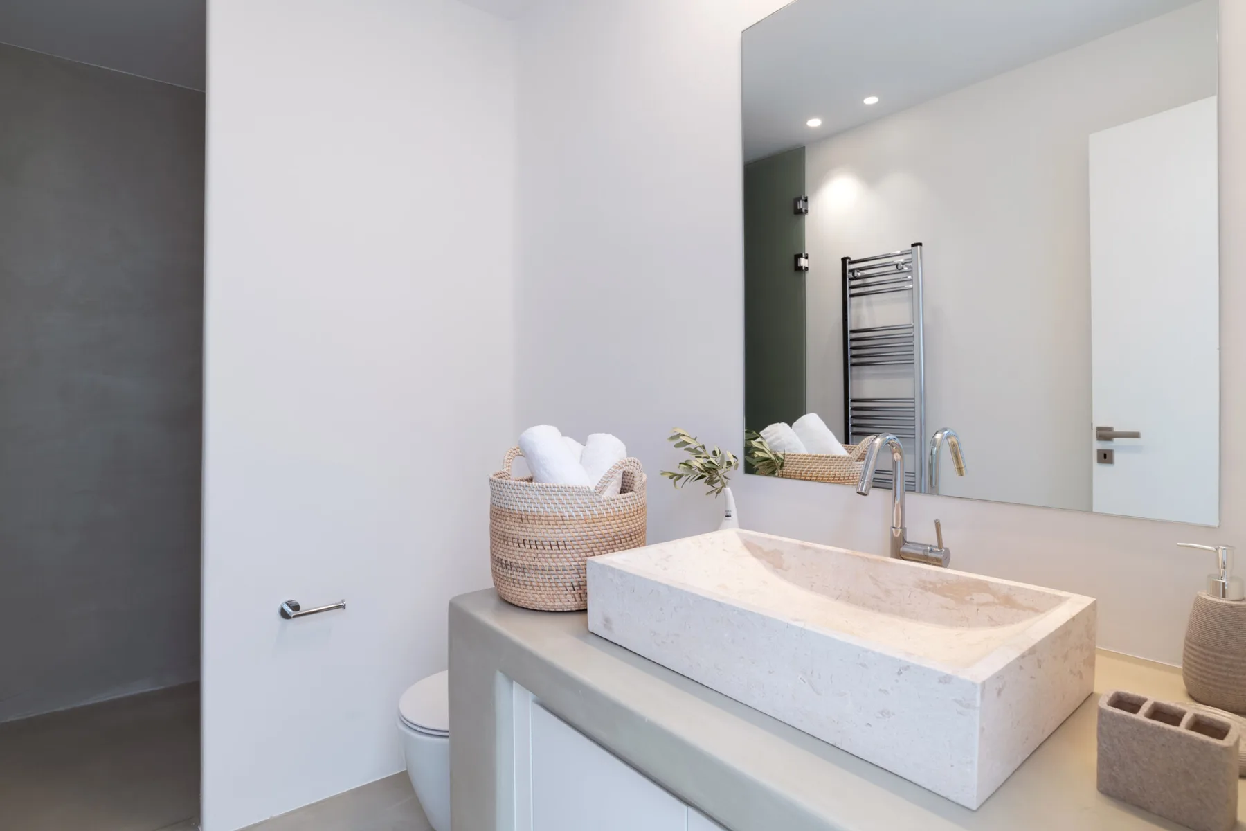 A modern bathroom with a large countertop sink and wall mirror.