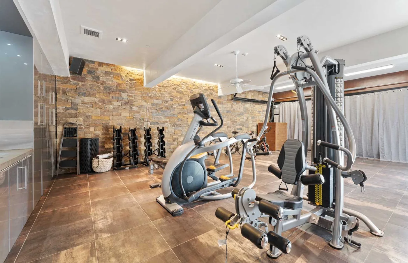 A fitness room with exercise machines and weight equipment.
