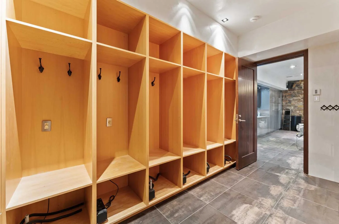 A wooden entry area with open storage cubbies and hooks.