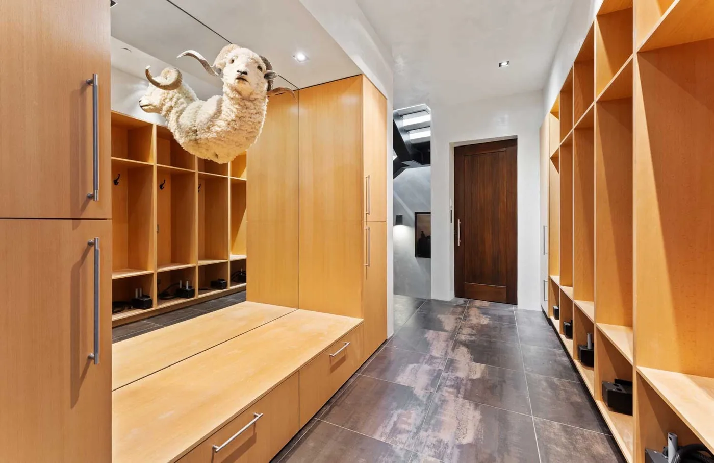 A hallway lined with wooden storage cubbies and built-in benches.