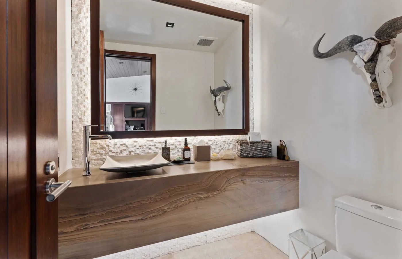 A bathroom vanity with a vessel sink sits beneath a large wall mirror.
