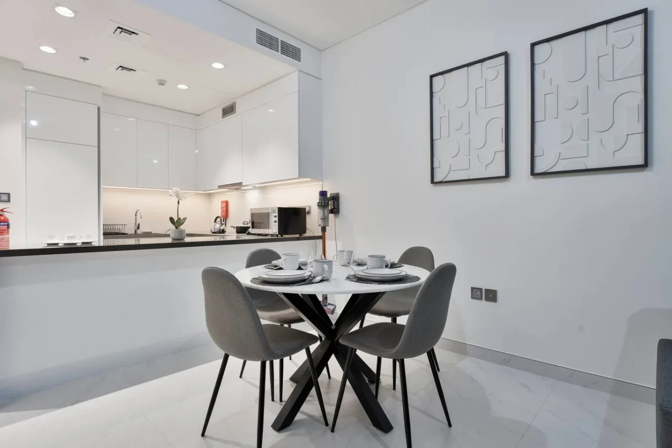 Comedor con una mesa y asientos junto a una cocina abierta.