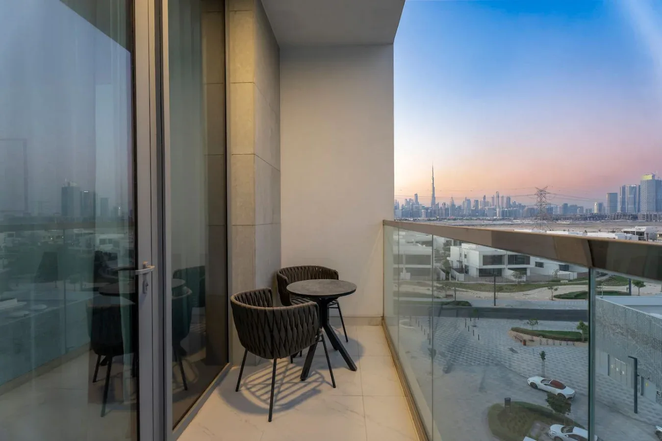 Un balcón con asientos ofrece vistas de un perfil urbano al atardecer.