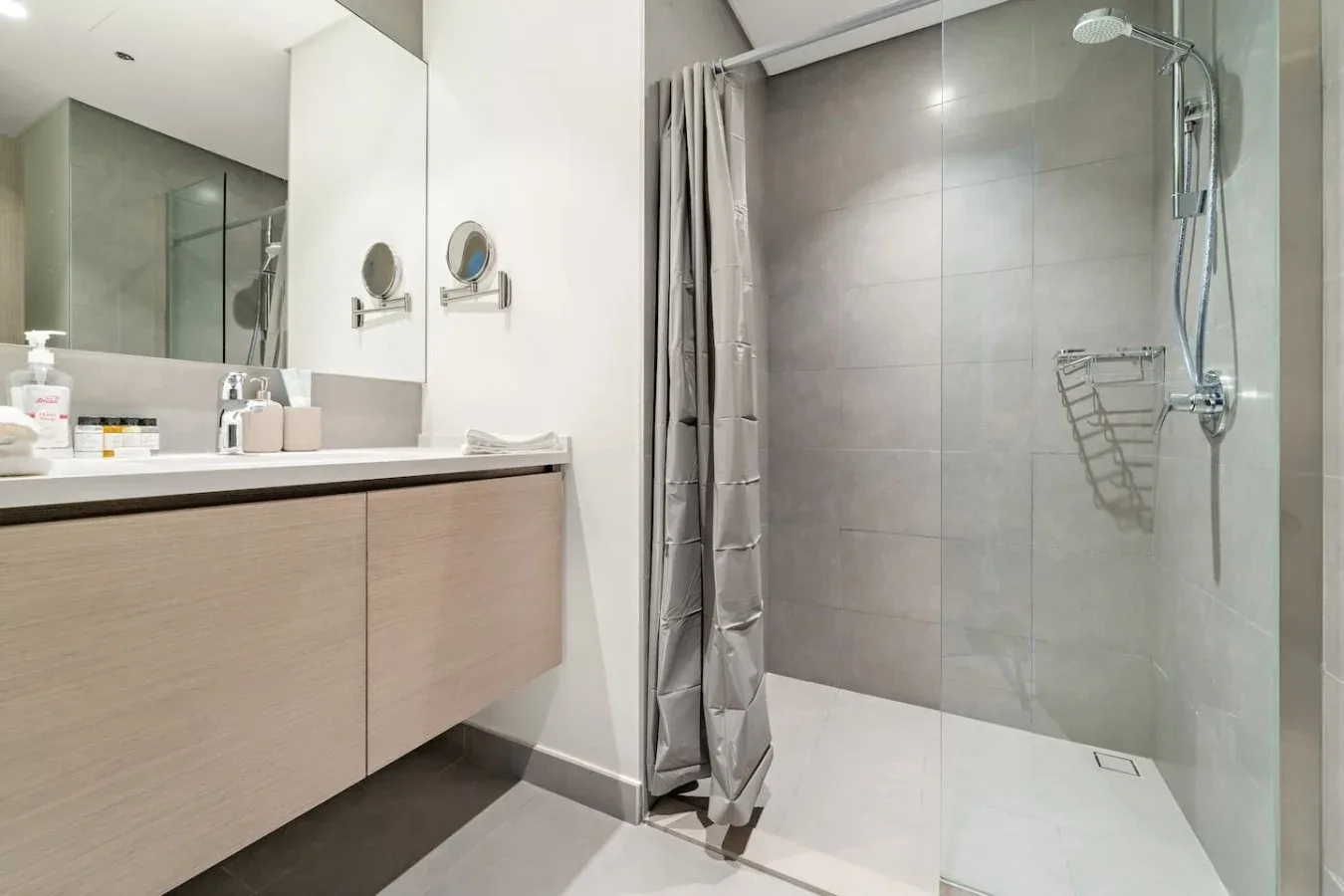 A modern bathroom with a wide vanity and a glass-enclosed shower.