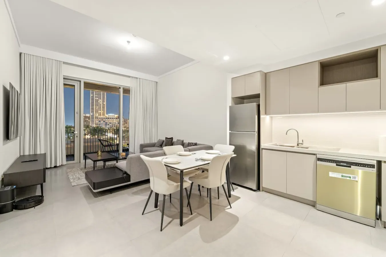 Una sala-comedor de planta abierta con cocina y grandes ventanales.