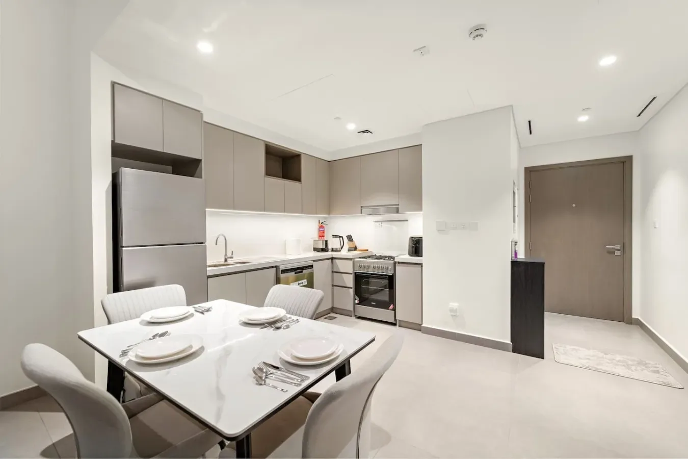 Una cocina luminosa con zona de comedor y una mesa junto a los armarios.