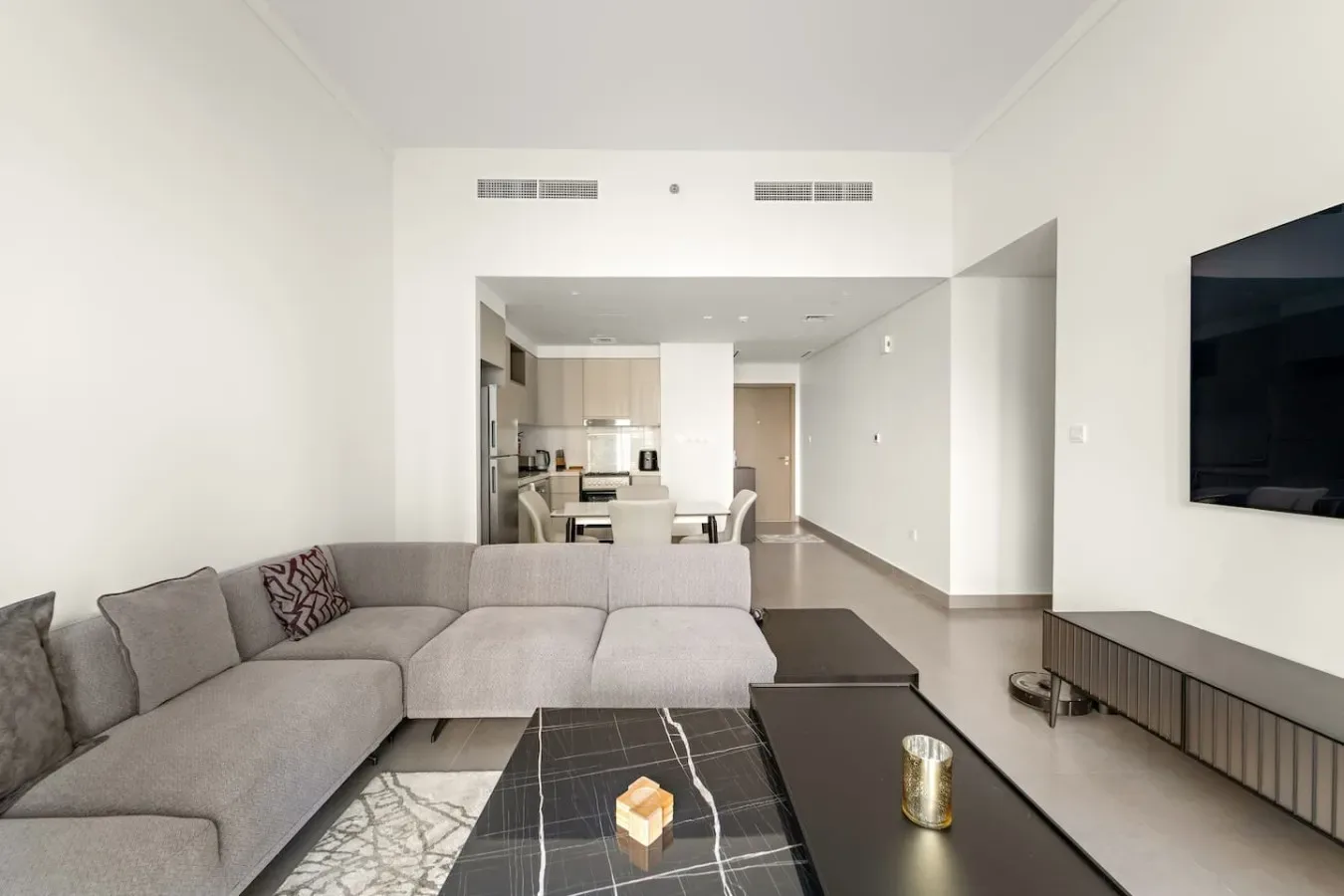 A bright living area with sectional seating, a coffee table, and a television.