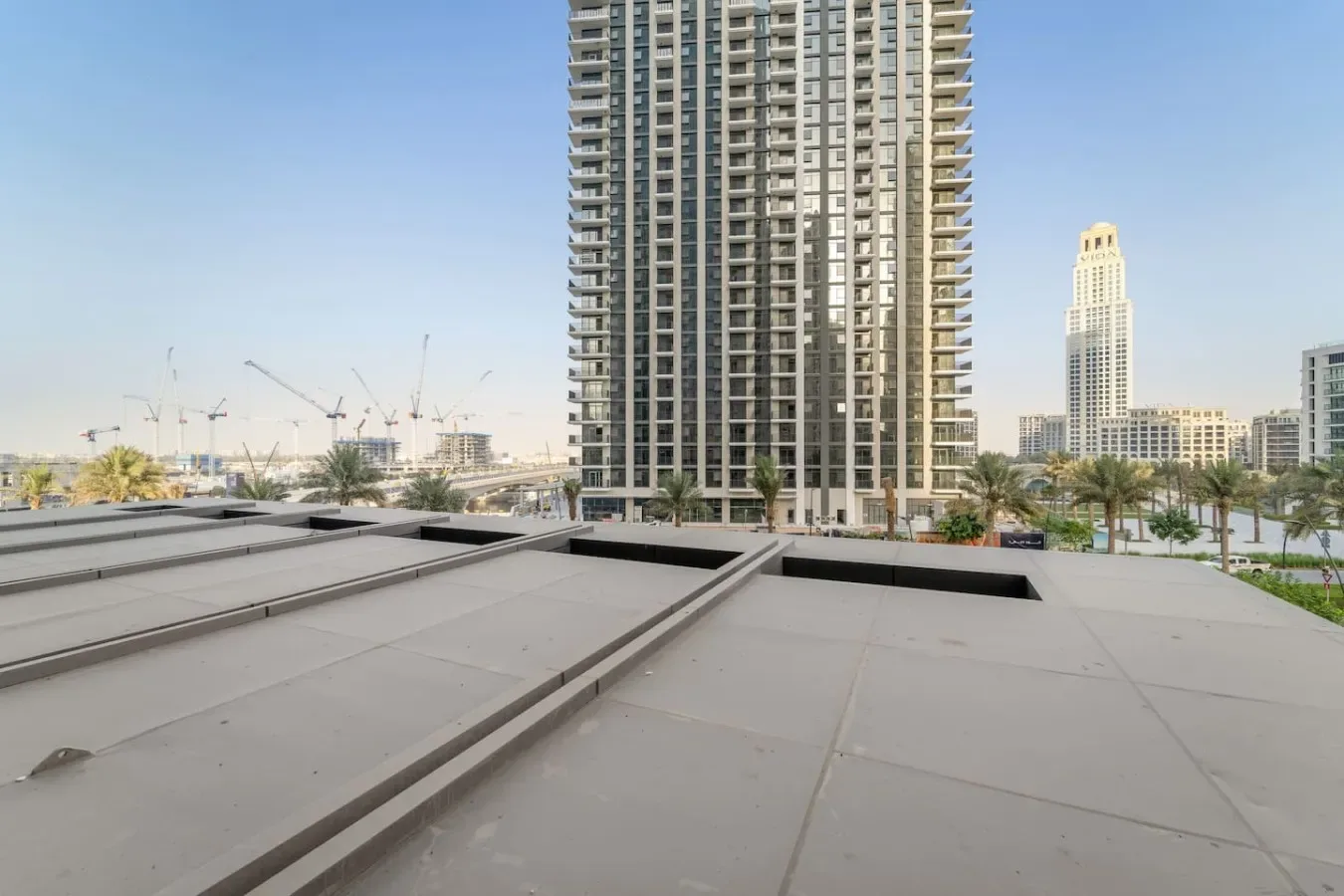 A city skyline rises beyond a broad rooftop in the foreground.