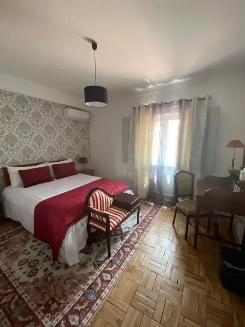 Habitación en Patio Da Villa con detalles rojos y papel pintado estampado.